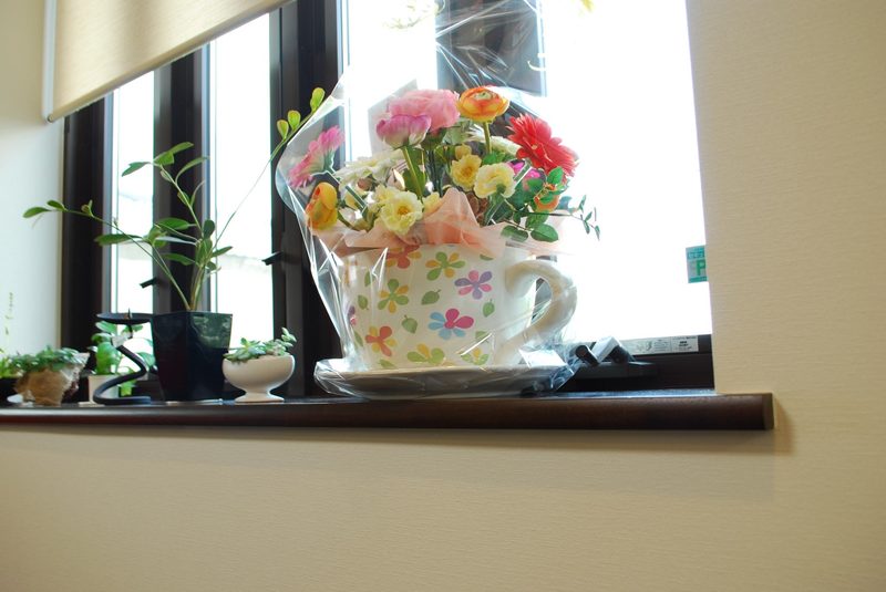 窓辺の花柄カップに生けた花
